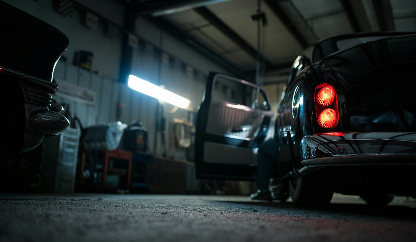 Inside the Vancity Autobody shop, cars under the work lights on the floor in East Vancouver